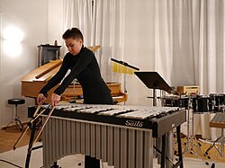 A vibraphonist using two double bass bows to play "Mourning Dove Sonnet" by Christopher Deane.