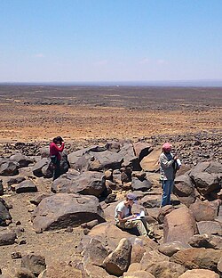 Archaeologists surveying a site in the Harrat al-Sham, eastern Jordan