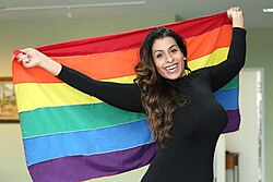 A rainbow flag held by a transgender person