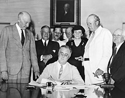 Roosevelt signs the Social Security Act into law, August 14, 1935.