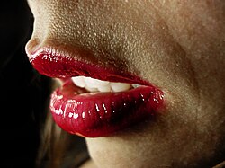 Lips of a young woman wearing red lipstick