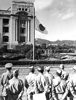 American soldiers lowering the Japanese flag at the former Japanese General Government Building, Seoul on 9 September 1945.