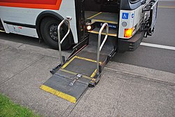 Portland, Oregon TriMet high-floor bus with wheelchair lift extended and lowered to the sidewalk/pavement (2010)