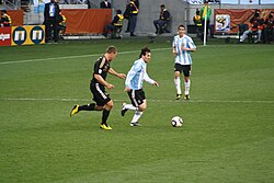 Lionel Messi carries out the ball, followed by Lukas Podolski in the quarter-finals of the 2010 World Cup.
