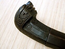 A Visayan tenegre horn hilt from the Philippines, depicting the moon-engulfing sea serpent deity, Bakunawa, a prominent figure in Philippine mythology.