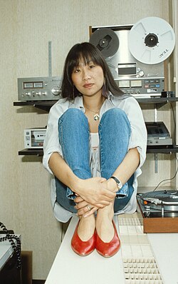 Picture of an Asian woman in her thirties sitting on a table