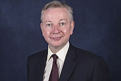 Gove facing forward in front of a dark background