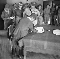 Major-General Wootten of the Australian 9th Division with Lieutenant-General Masao Baba (signing) of the Japanese 37th Army at the surrender ceremony at Labuan on 10 September 1945