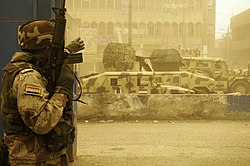 An Iraqi soldier and vehicles from the 42nd Brigade, 11th Iraqi Army Division during a firefight with armed militiamen in the Sadr City district of Baghdad 17 April 2008