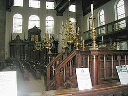 Interior of the Portuguese Synagogue of Amsterdam, with the tebáh (bimah) in the foreground and the Hekhál (Torah ark) in the background.