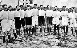 Italy in 1910, wearing the original white jersey. They would switch to the traditional blue shirt a year later.