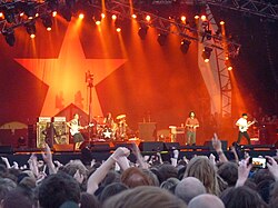 Rage Against the Machine performing in front of the flag of the Zapatista Army of National Liberation.