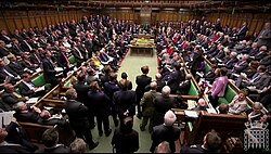 A wide shot of Prime Ministers Questions in 2012, showing the House of Commons packed with members