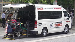 Wheelchair accessible maxicab, unloading a wheelchair-using passenger in Australia