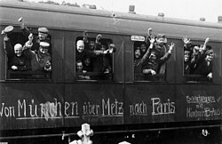 German soldiers in a railway car on the way to the front in August 1914. The message on the car reads Von München über Metz nach Paris ("From Munich via Metz to Paris").