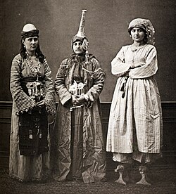 Three Damascene women, 1873: peasant (left), Druze in tantour headdress, and urban lady wearing qabqab (i.e. kabkab or platform shoes)