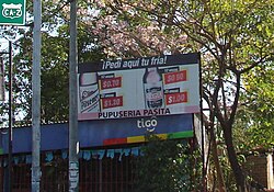 Voseo used on a billboard in El Salvador: ¡Pedí aquí tu fría! ("Order your cold one here!"). The tuteo equivalent would have been ¡Pide aquí tu fría!