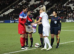 United States captain Abby Wambach (left, in red) and England captain Steph Houghton (right, in white) shake hands before kickoff, 2015