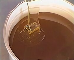 Pouring raw honey. The sheet-like appearance of the flow is the result of high viscosity and low surface tension, contributing to the stickiness of honey.[49][50]