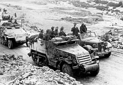 Rommel speaking with troops using a captured American M3 half-track, Tunisia