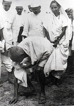 Gandhi picking salt during Salt Satyagraha to defy colonial law giving salt collection monopoly to the British.[237] His satyagraha attracted vast numbers of Indian men and women.[238]