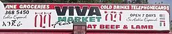 A grocery store sign in Dallas, TX in three languages English, Amharic, and Spanish.