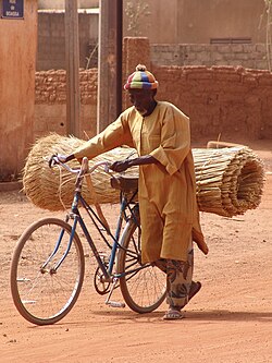 A man uses a bicycle to carry goods in Ouagadougou, Burkina Faso.