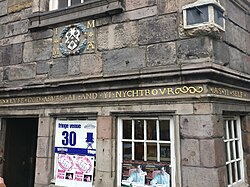 Lufe God abufe al and yi nychtbour as yi self ("Love God above all and thy neighbour as thyself"), an example of Early Scots, on John Knox House, Edinburgh