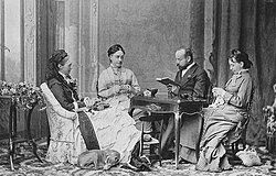 Charles Woodcock reads in Nice to Queen Olga of Württemberg in the arm chair and two ladies-in-waiting