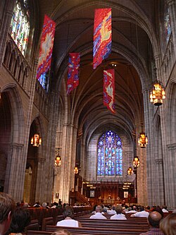The interior, looking east from about halfway through the nave. The choir and the east window, titled "The Love of Christ", are in the background.
