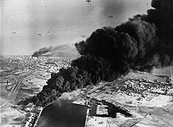 Smoke rises from oil tanks beside the Suez Canal hit during the initial Anglo-French assault on Port Said, 5 November 1956.