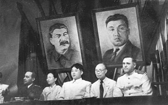 Kim Tu-bong (right) sitting next to Kim Il Sung (center)
