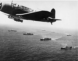 A SB2U Vindicator scout bomber from USS Ranger flies anti-submarine patrol over Convoy WS-12, en route to Cape Town, 27 November 1941. The convoy was one of many escorted by the US Navy on "Neutrality Patrol", before the US officially entered the war.