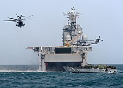 Marines from the 15th Marine Expeditionary Unit depart USS Tarawa (LHA-1), using both a Landing Craft Utility and CH-53E "Super Stallion" helicopters, during amphibious operations in Kuwait, 2003.