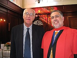 A South African PhD graduate (on the right, wearing a ceremonial gown)