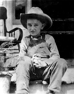 Johnson at age 7, wearing his trademark cowboy hat, at his childhood farmhouse near Stonewall, Texas, in 1915