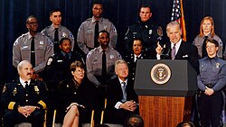 Photo of Senator Biden giving a speech, with uniformed law enforcement officers in the background