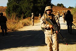 A United States Marine providing rear security to his unit during a simulated patrol in 2009