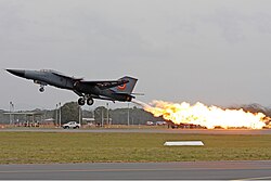 A Royal Australian Air Force F-111C performing a dump-and-burn, a procedure where fuel is intentionally ignited using the aircraft's afterburner