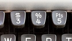 A 1970s AEG Olympia Traveller de Luxe typing machine with the ₧ symbol