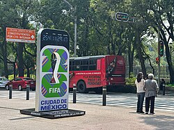 A freestanding digital clock with Fifa branding placed on the sidewalk.