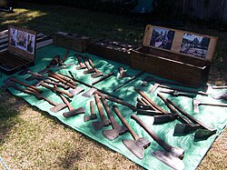 A collection of old Australian cutting tools including broad axes, broad hatchets, mortising axes, carpenter's axes, and felling axes. Also five adzes, a corner chisel, two froes, and a twybil.