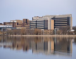 A view of UW Health University Hospital, the Health Sciences Learning Center (HSLC), and the Wisconsin Institutes for Medical Research rising above Lake Mendota, on the western edge of the UW–Madison campus. The University of Wisconsin School of Medicine and Public Health, housed in the HSLC, accounts for 40% of UW–Madison's research grants.[150]