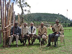 A group of men gather in a rural village for health training.
