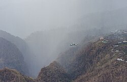 A SH-60 Seahawk flies over Dominica en route to deliver humanitarian aid. The mountainous terrain of the island poses serious challenges to relief operations in more remote areas.
