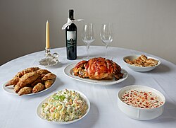 The traditional Christmas table often features roast pork, hearty soup, crescent rolls, and Olivier salad, accompanied by wine or rakija.