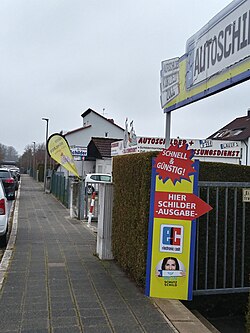 Several shops advertising Schilder (plates), in the street of the registration authority