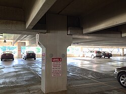 Precast parking structure showing an interior column, girders and double-tee structural floors. The two gray circles are covers to close the lifting anchor holes.