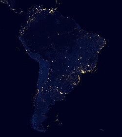 Satellite view of South America at night from NASA, showing the contrast between heavily populated coastal areas and the more remote regions of the Amazonian interior and Patagonia