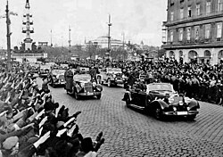 Crowds greet German Chancellor Adolf Hitler as he rides in an open car in Vienna following the March 1938 annexation of Austria by Nazi Germany.